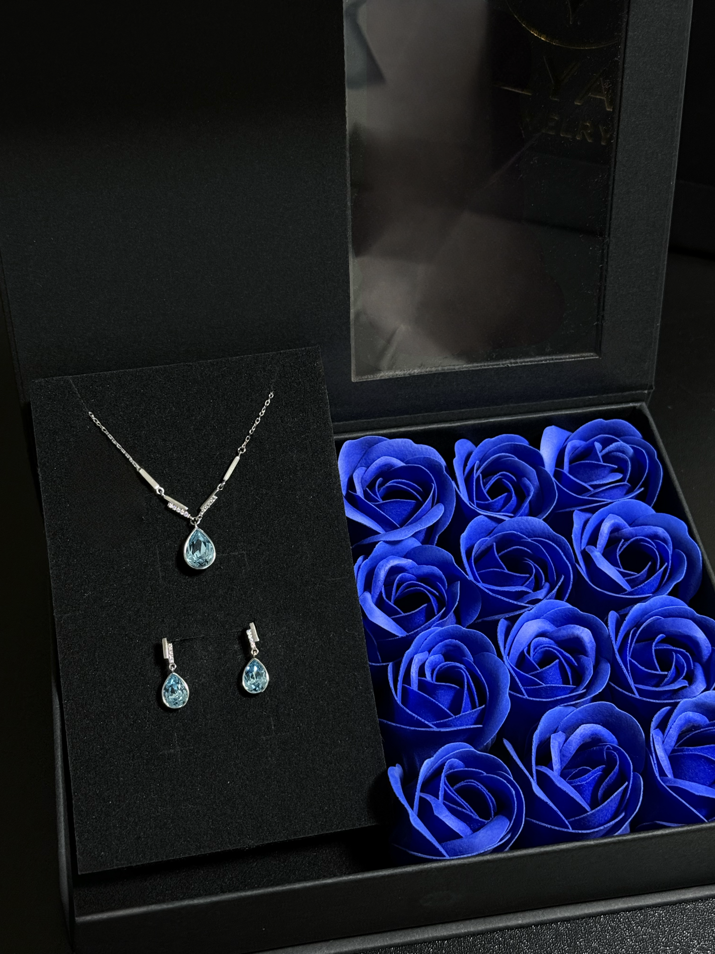 Elegantes Schmuck-Set aus 925er Sterlingsilber mit Swarovski-Kristallen im Tropfendesign – Halskette und Ohrringe in Blau oder Rosa, präsentiert in einer Blumen-Geschenkbox