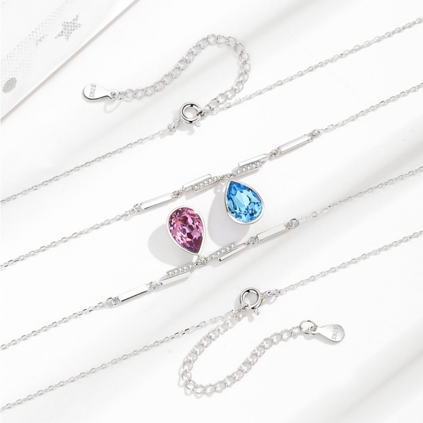 Elegantes Schmuck-Set aus 925er Sterlingsilber mit Swarovski-Kristallen im Tropfendesign – Halskette und Ohrringe in Blau oder Rosa, präsentiert in einer Blumen-Geschenkbox
