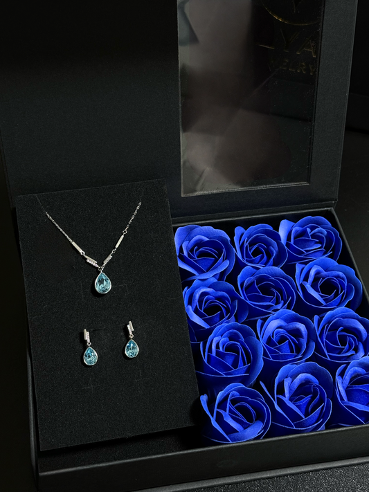 Elegantes Schmuck-Set aus 925er Sterlingsilber mit Swarovski-Kristallen im Tropfendesign – Halskette und Ohrringe in Blau oder Rosa, präsentiert in einer Blumen-Geschenkbox